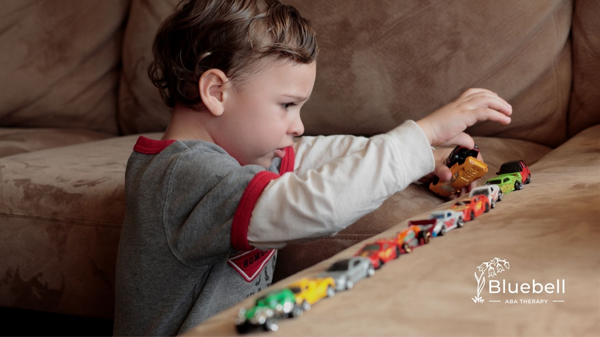 A little boy playing with his toy cars
