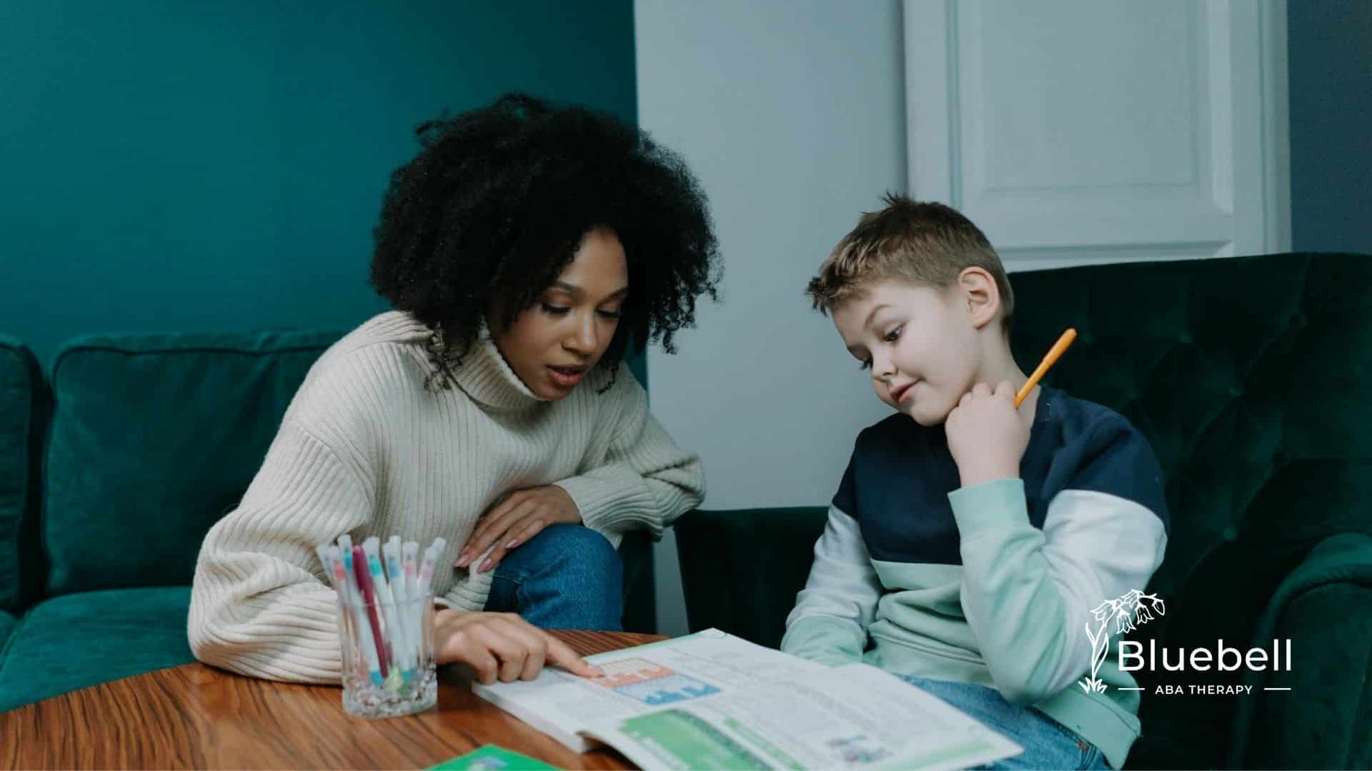 An ABA therapist helping an autistic boy with reading and homework at a cozy home in North Carolina.