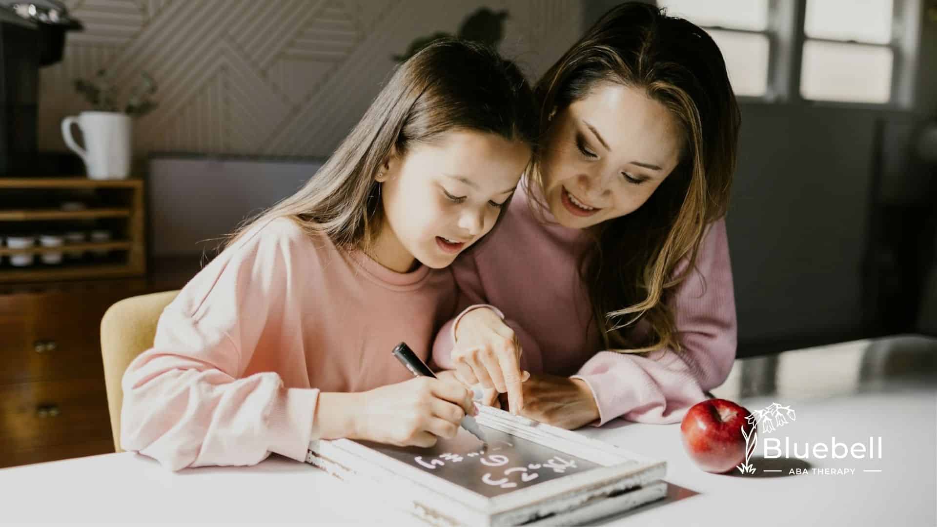 ABA therapist teaching an autistic girl math using a whiteboard, with an apple on the table in NC.