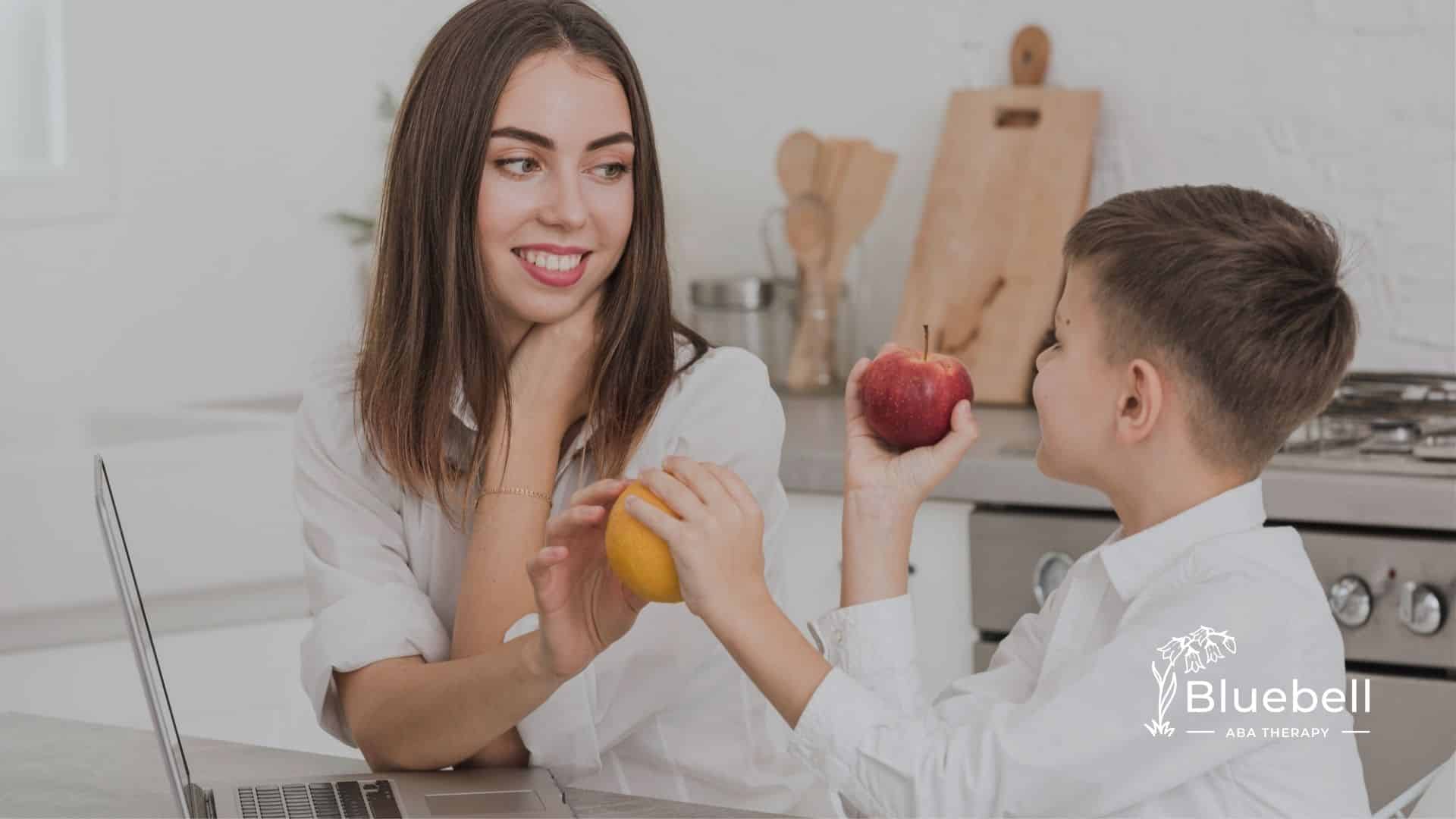 Boy and ABA therapist comparing an apple and orange.