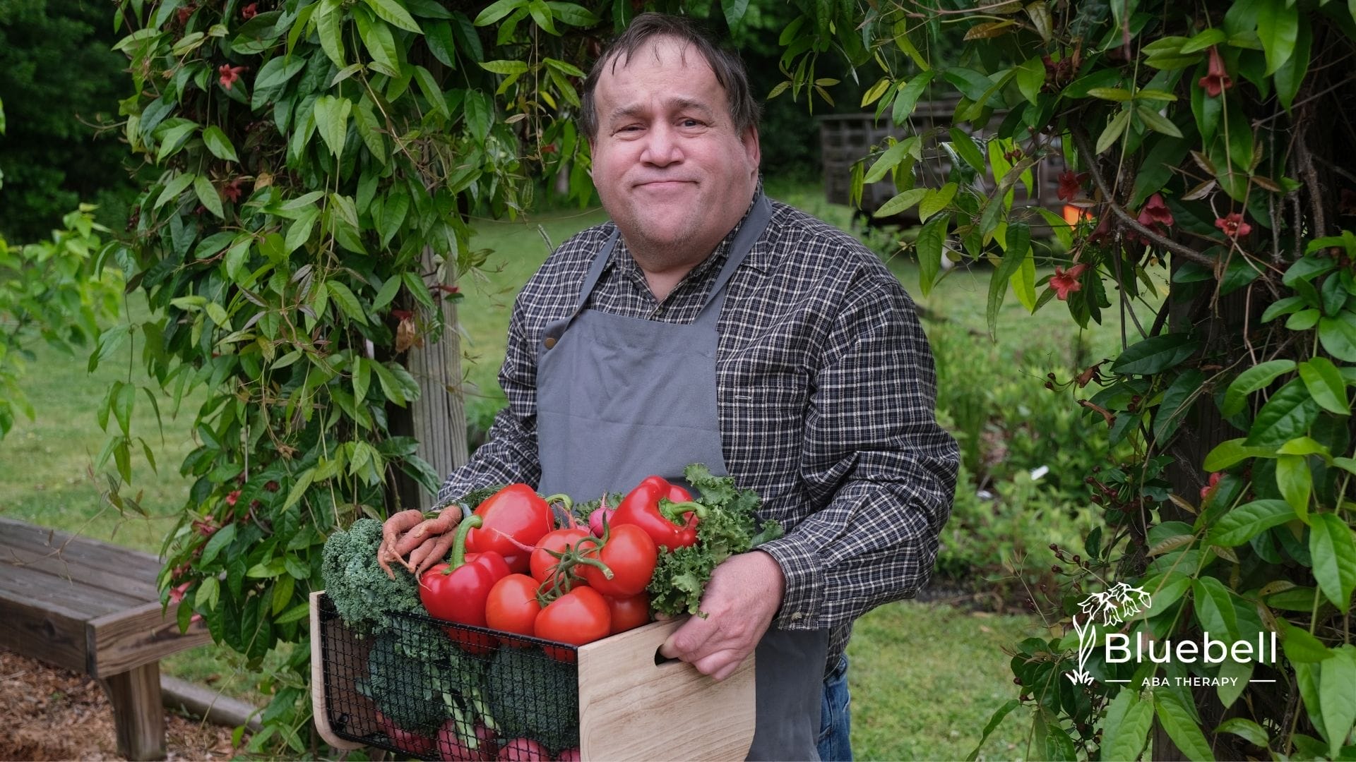 A man holding a basket of fresh tomatoes in the garden