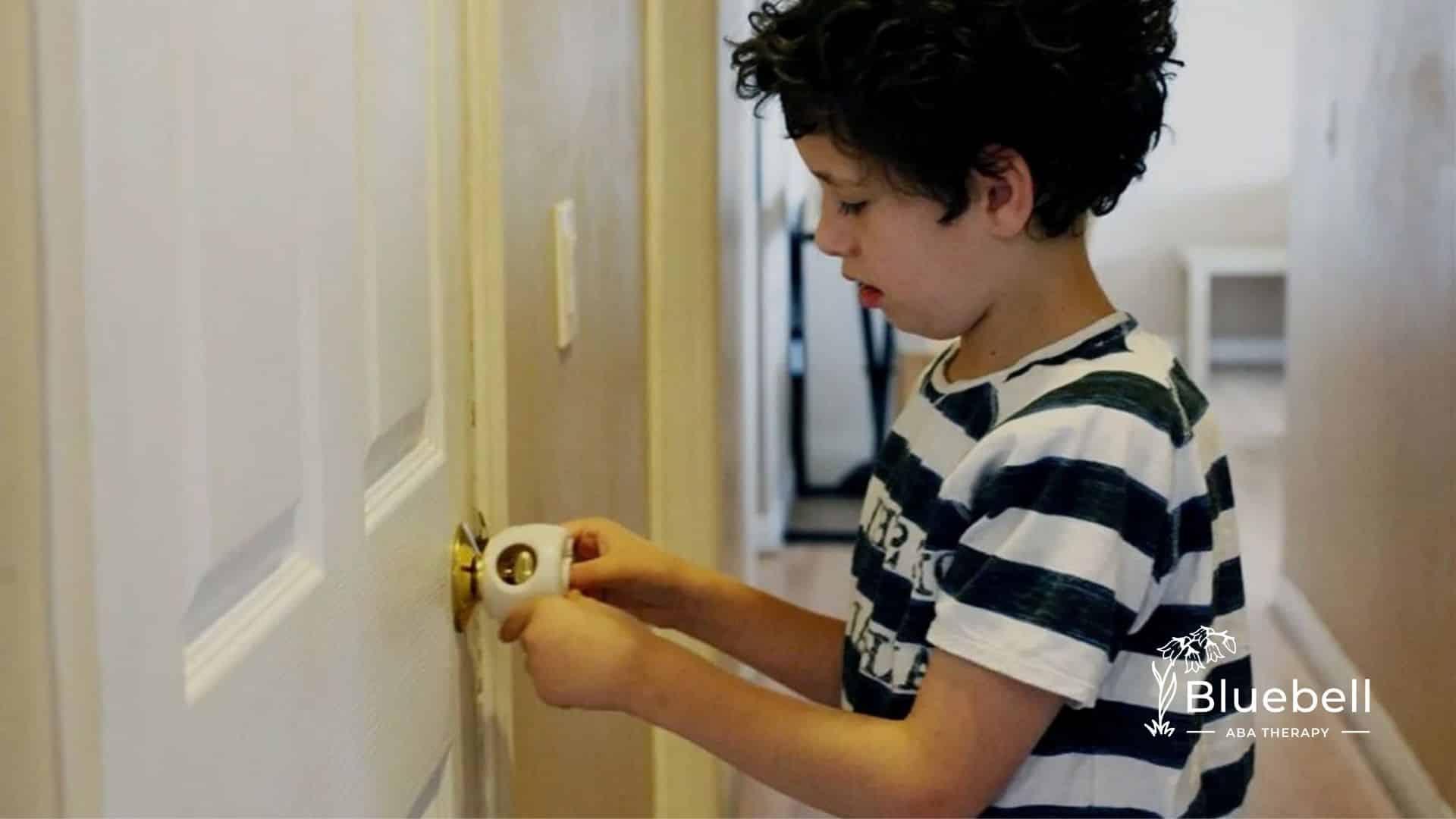 An autistic boy with curly hair unlocking a door with a white safety device in North Carolina.