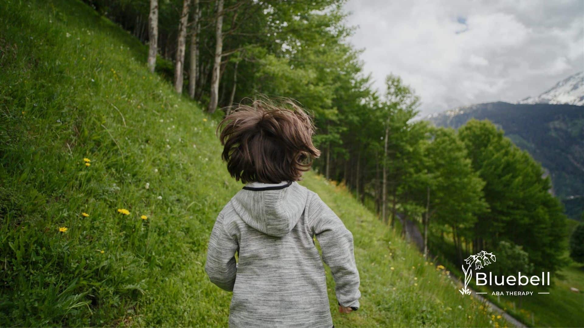 An autistic child running through a hillside forest in North Carolina, showing elopement behavior.