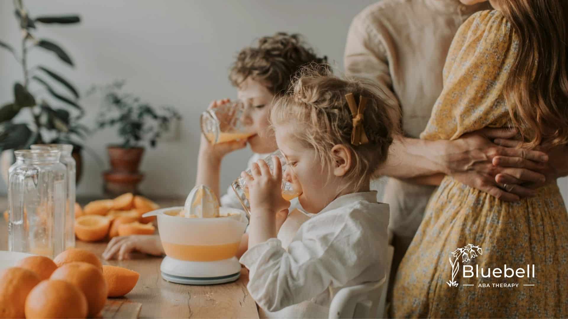 Autistic girl drinking orange juice with family while oranges sit on the table in North Carolina.