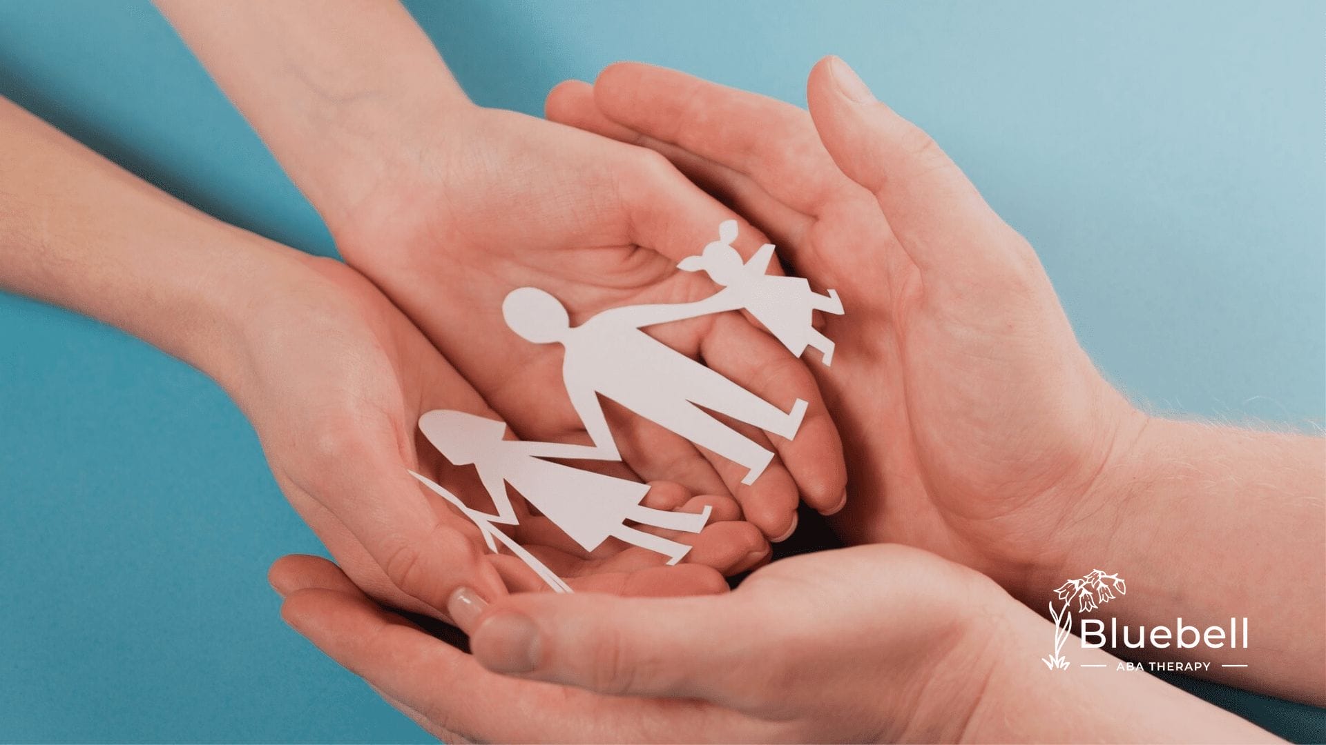 An autistic child and his parent are holding a cutout of a family