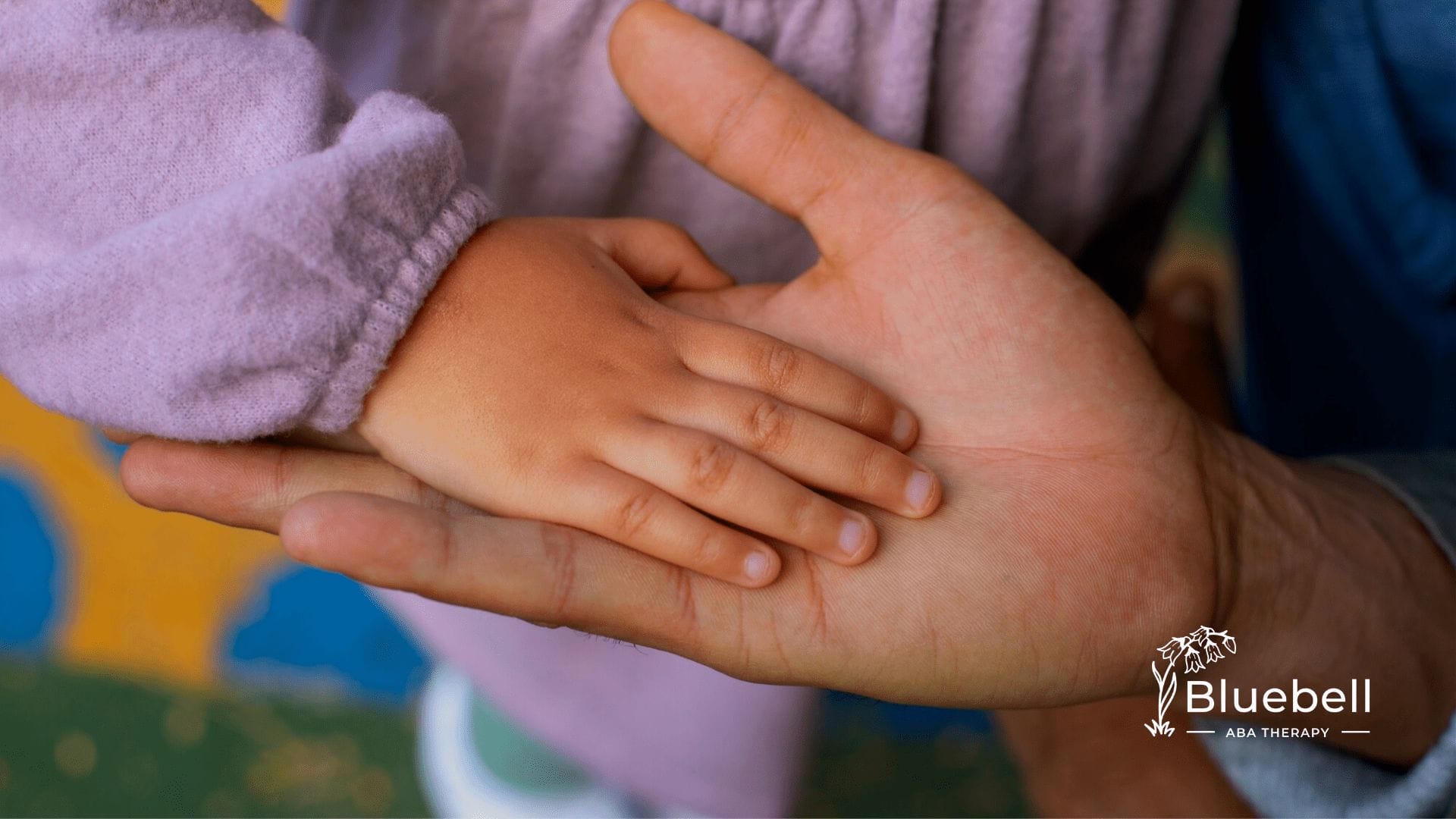 Hands of an autistic child and her parent