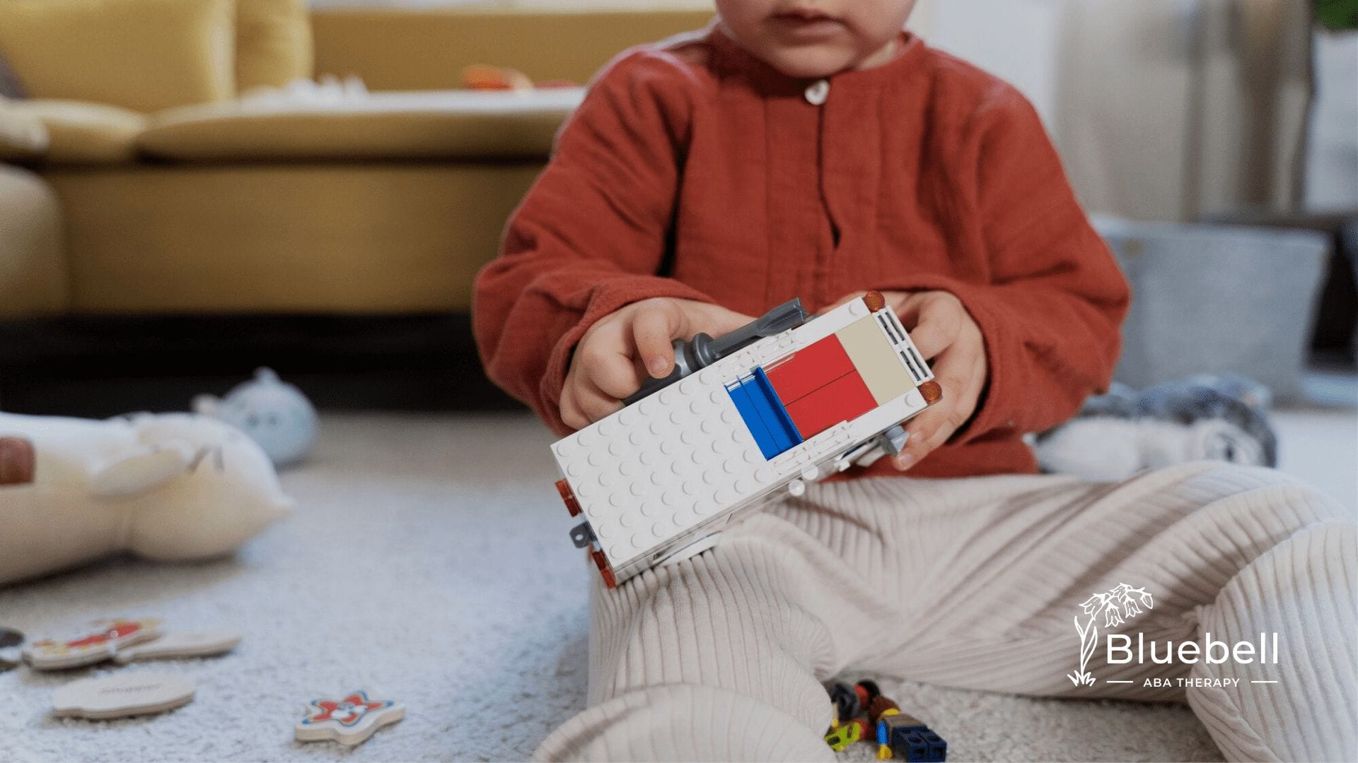 A boy with autism is playing with a toy truck