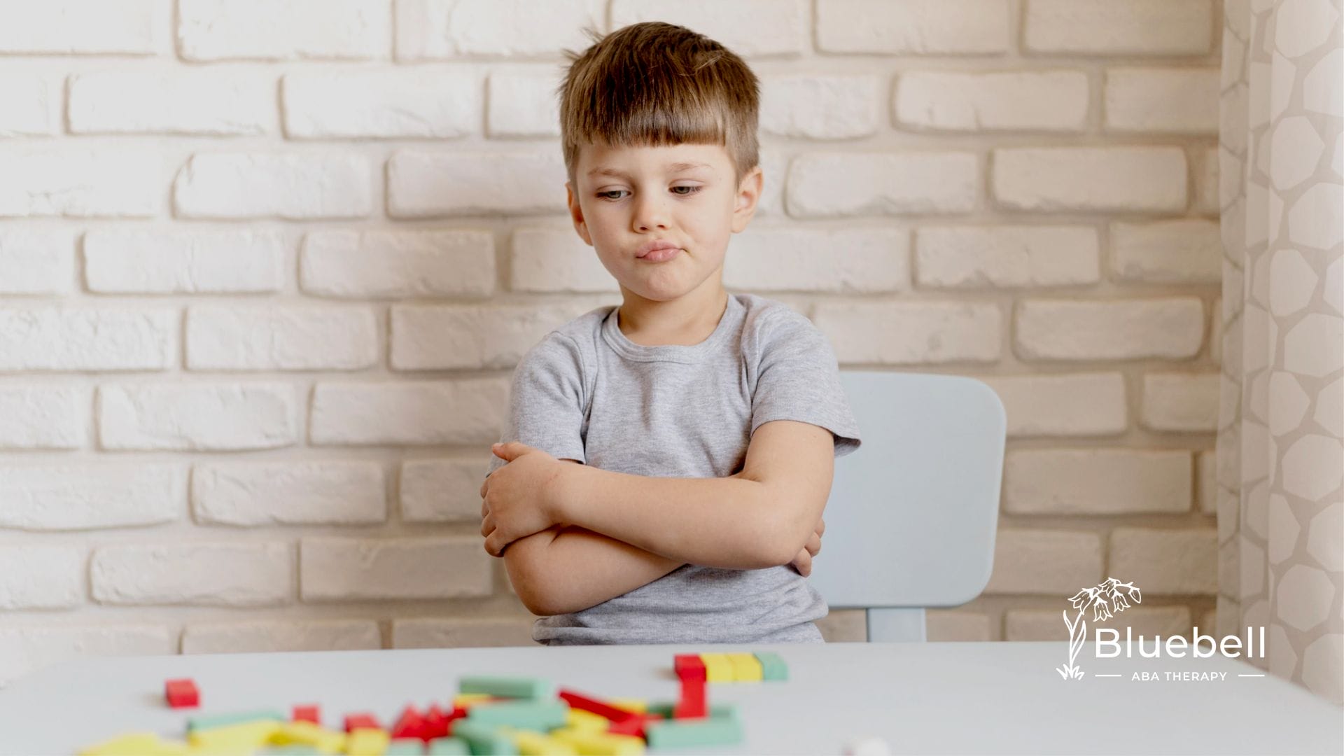 A kid with autism staring at colorful blocks on the table