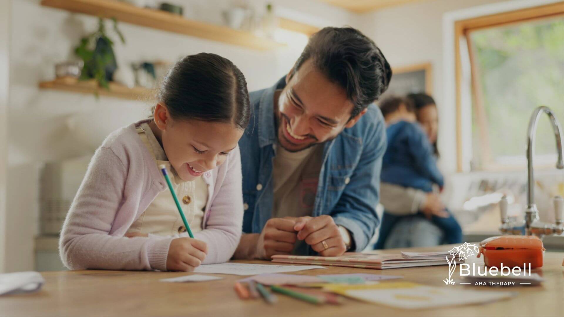 BCBA helping young child with homework at home during ABA therapy.